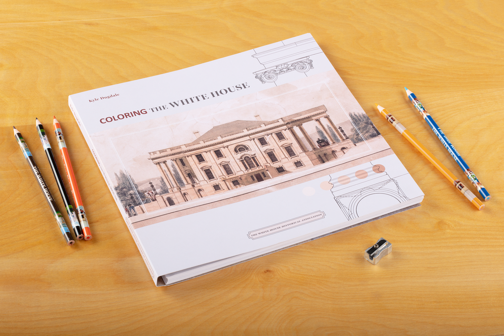 Coloring the White Housewith colored pencils on a table.