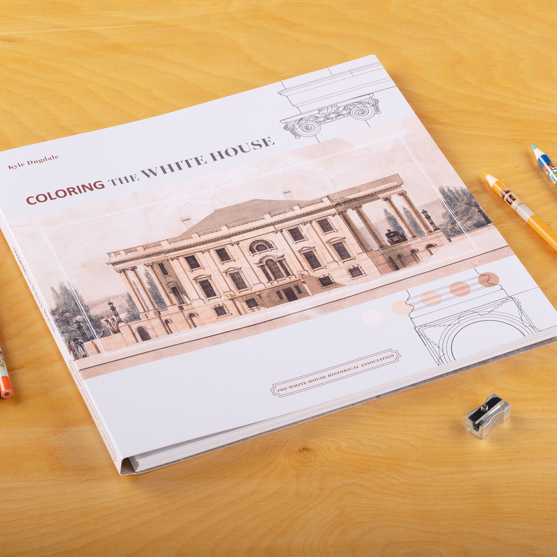 Coloring the White Housewith colored pencils on a table.